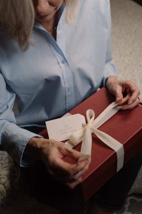 Woman in Blue Dress Long Sleeves Holding a Gift Box