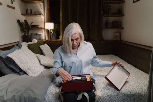 An Elderly Woman Opening a Box of Gift