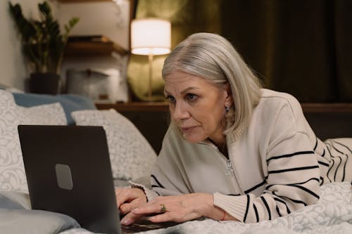 A Woman Using a Laptop in Bed