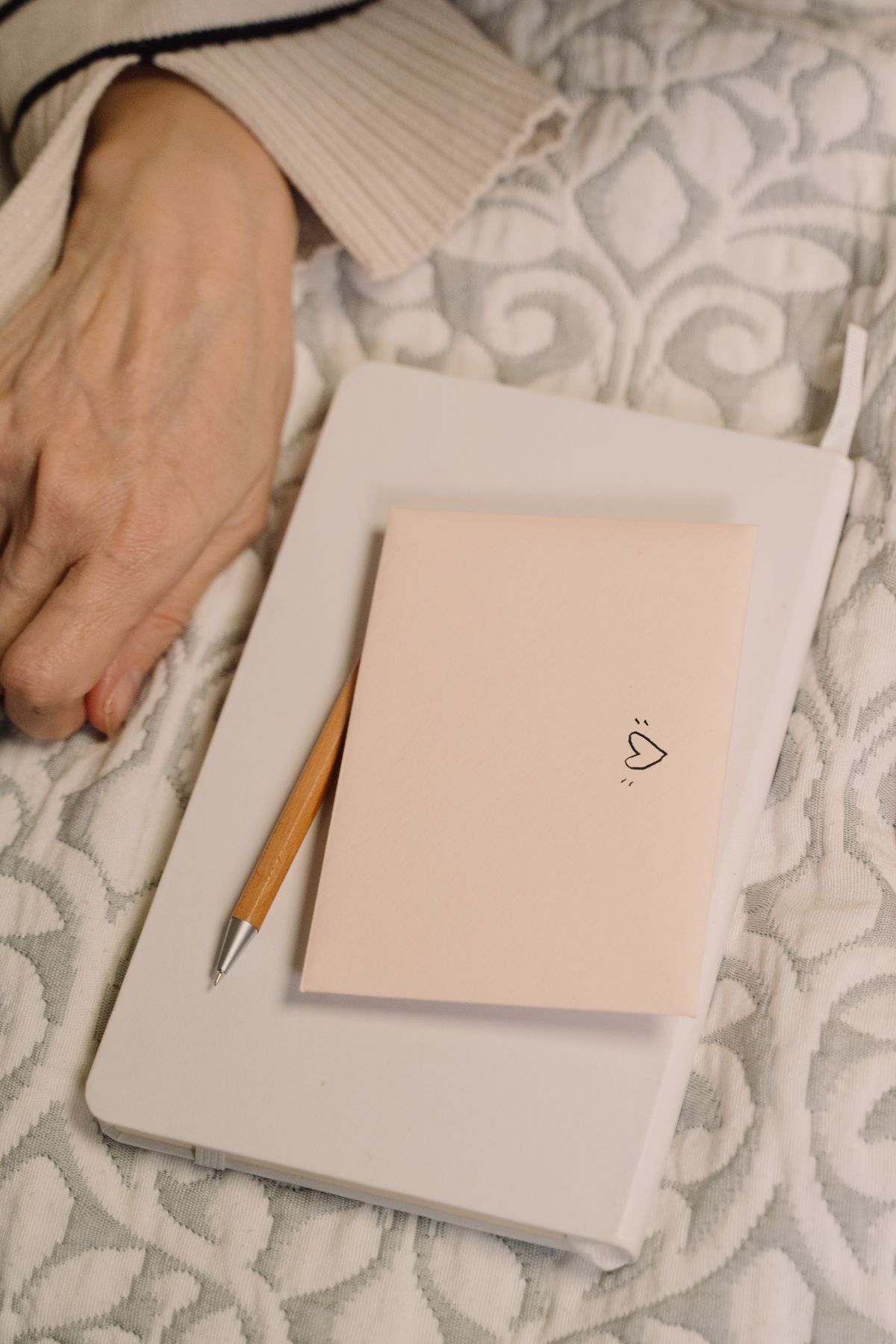 A journal decorated with a heart and a pen resting in a cozy, intimate space