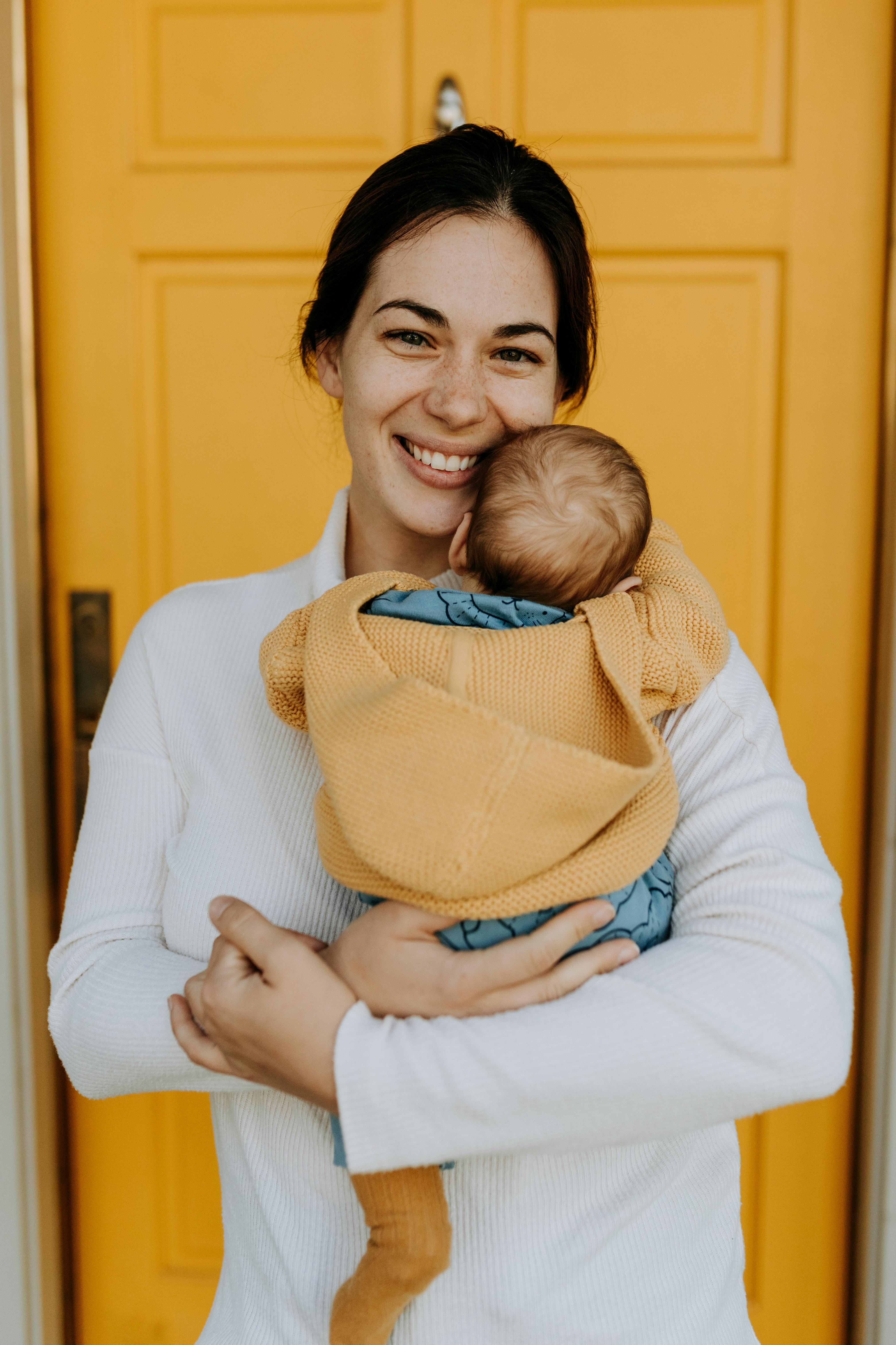 A Woman Carrying a Baby · Free Stock Photo