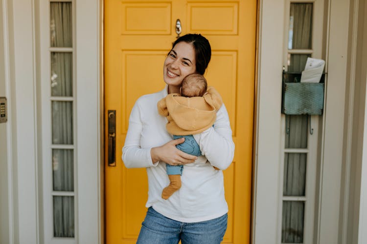 Woman In White Long Sleeves Holding Her Baby