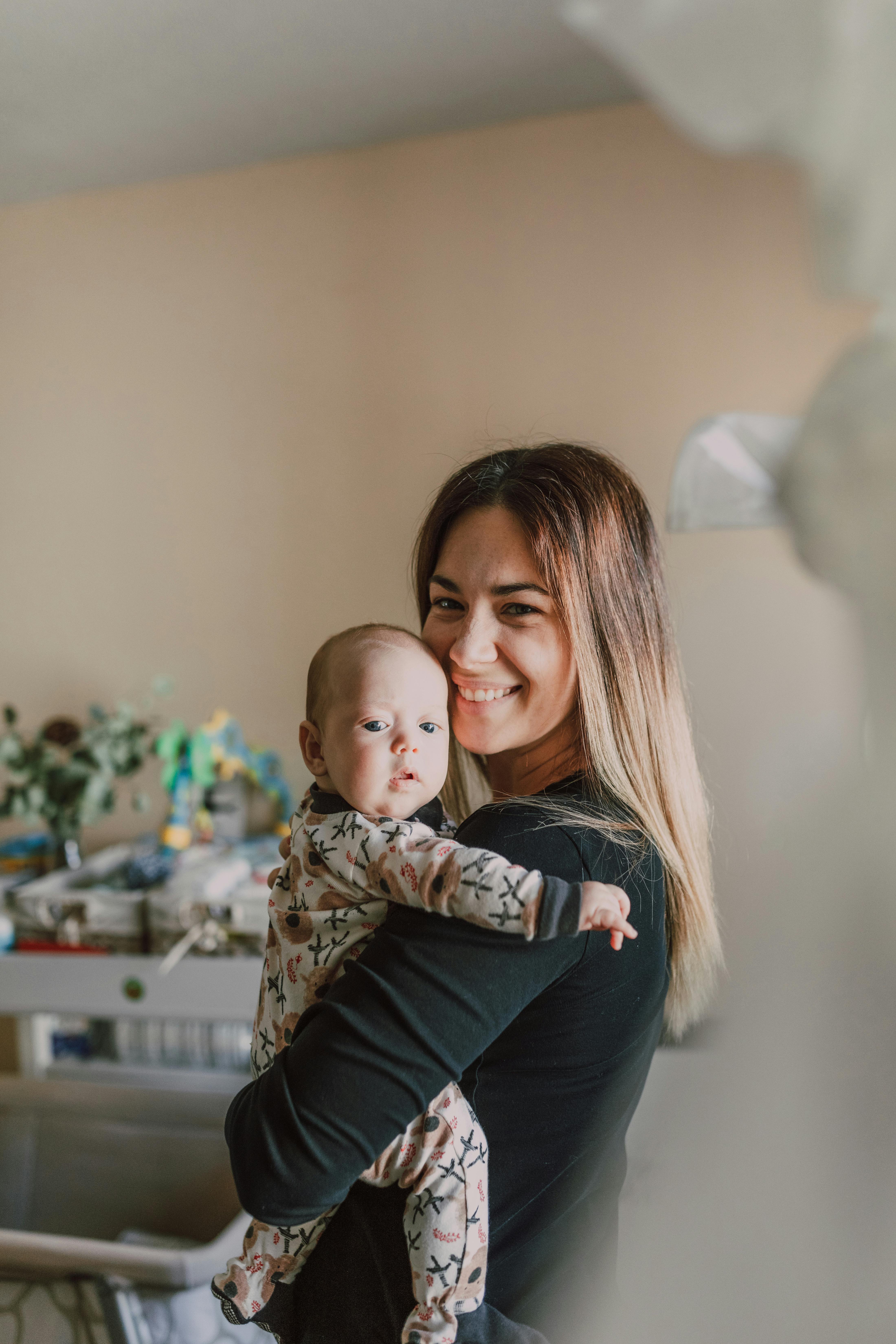 smiling woman carrying her precious baby