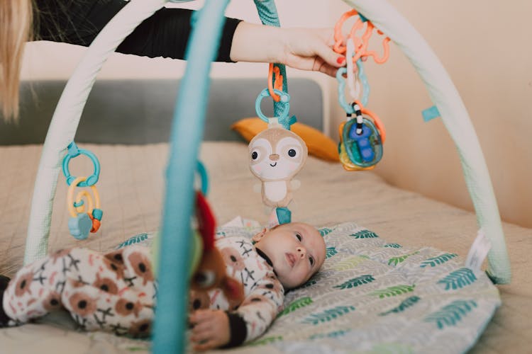 A Baby Lying On A Baby Bed