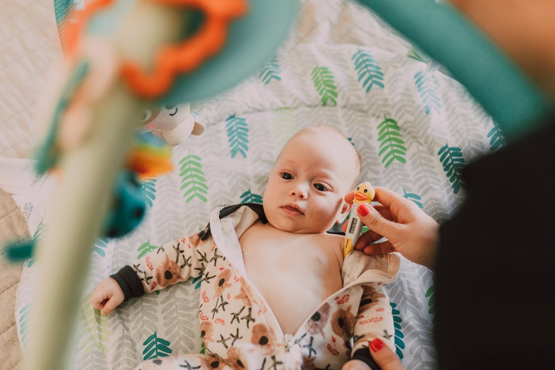 Free A Cute Baby in Onesie Lying Down Stock Photo