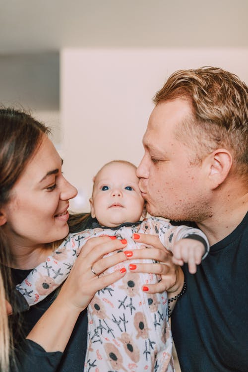 A Couple Cuddling Their Baby