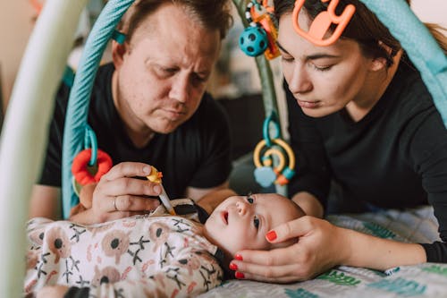 Man Checking the Baby's Temperature using Thermometer