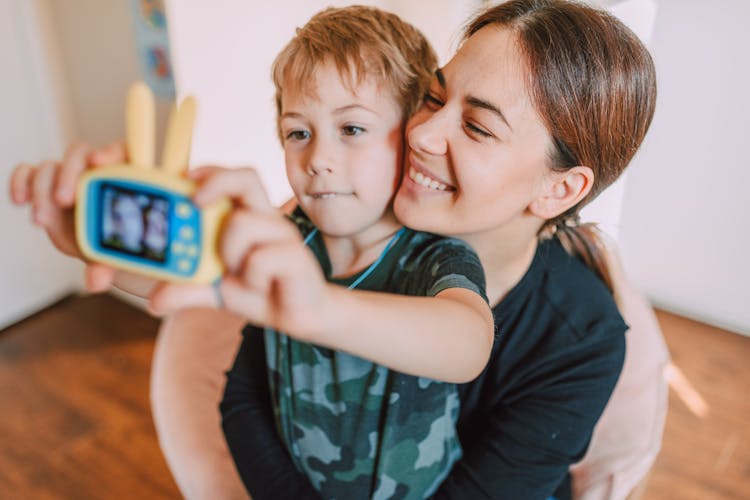 A Young Boy Taking Picture With His Mother