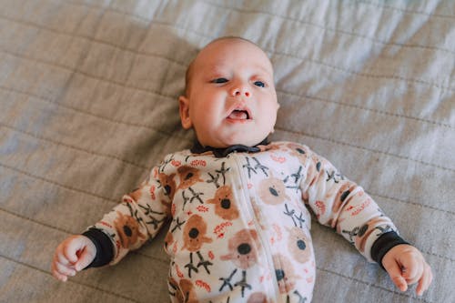 Free A Cute Baby in Onesie Lying Down Stock Photo