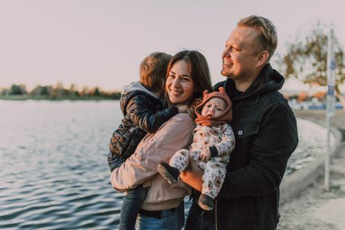 Free A joyful family with children enjoying a sunset by the lake, capturing love and togetherness. Stock Photo