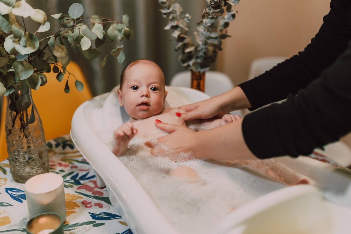Baby receiving a gentle bath from a caregiver