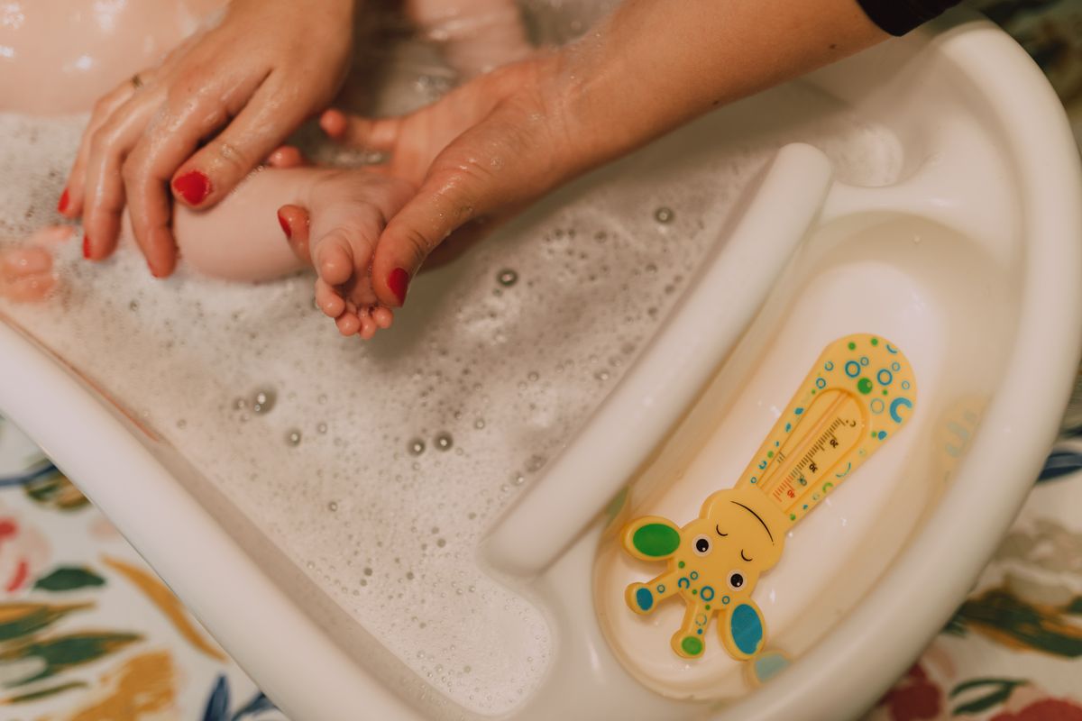 Parent gently caring for baby during bath time