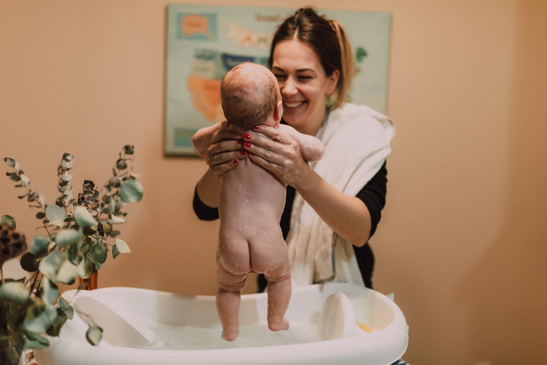 Madre En Un Pañuelo Sentado En Una Bañera De Hidromasaje Y Un Bebé Grande  En Sus Brazos Fotos, retratos, imágenes y fotografía de archivo libres de  derecho. Image 87877943