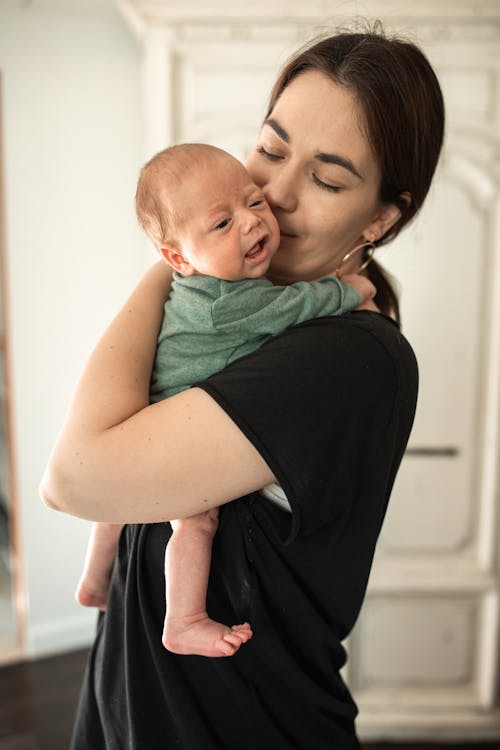 Woman in Black Shirt Carrying Baby