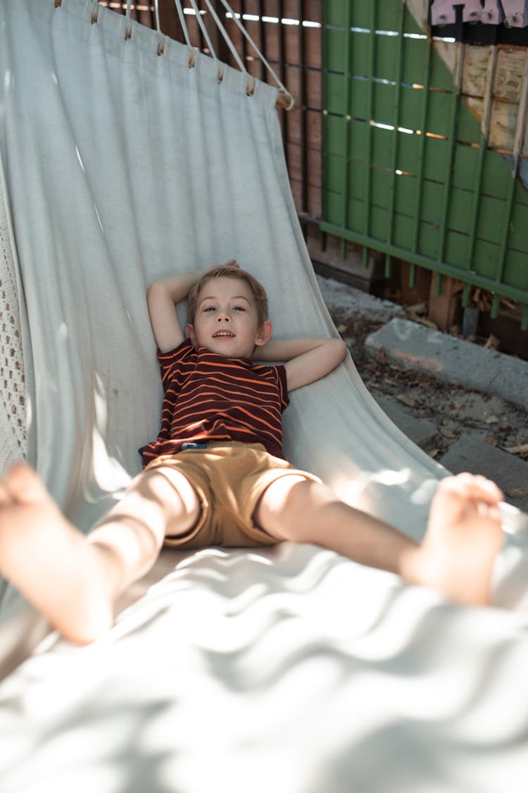 A Young Boy Chilling On A Hammock