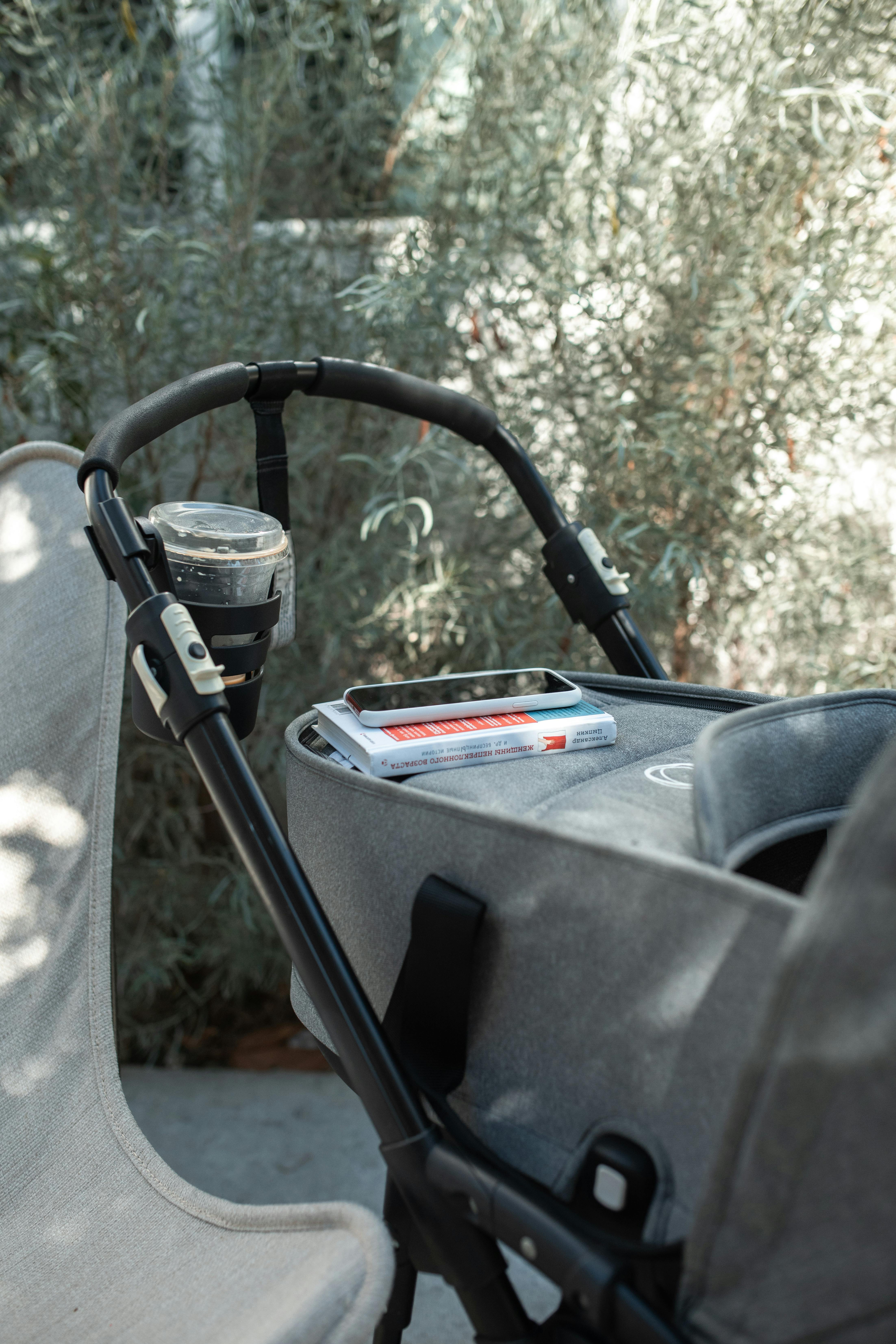 A Cellphone And A Book Placed Over A Stroller · Free Stock Photo