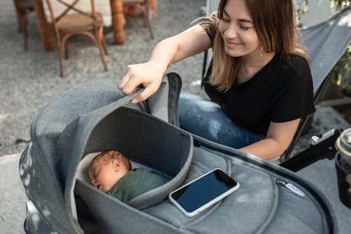 Woman Looking at Her Baby in a Stroller