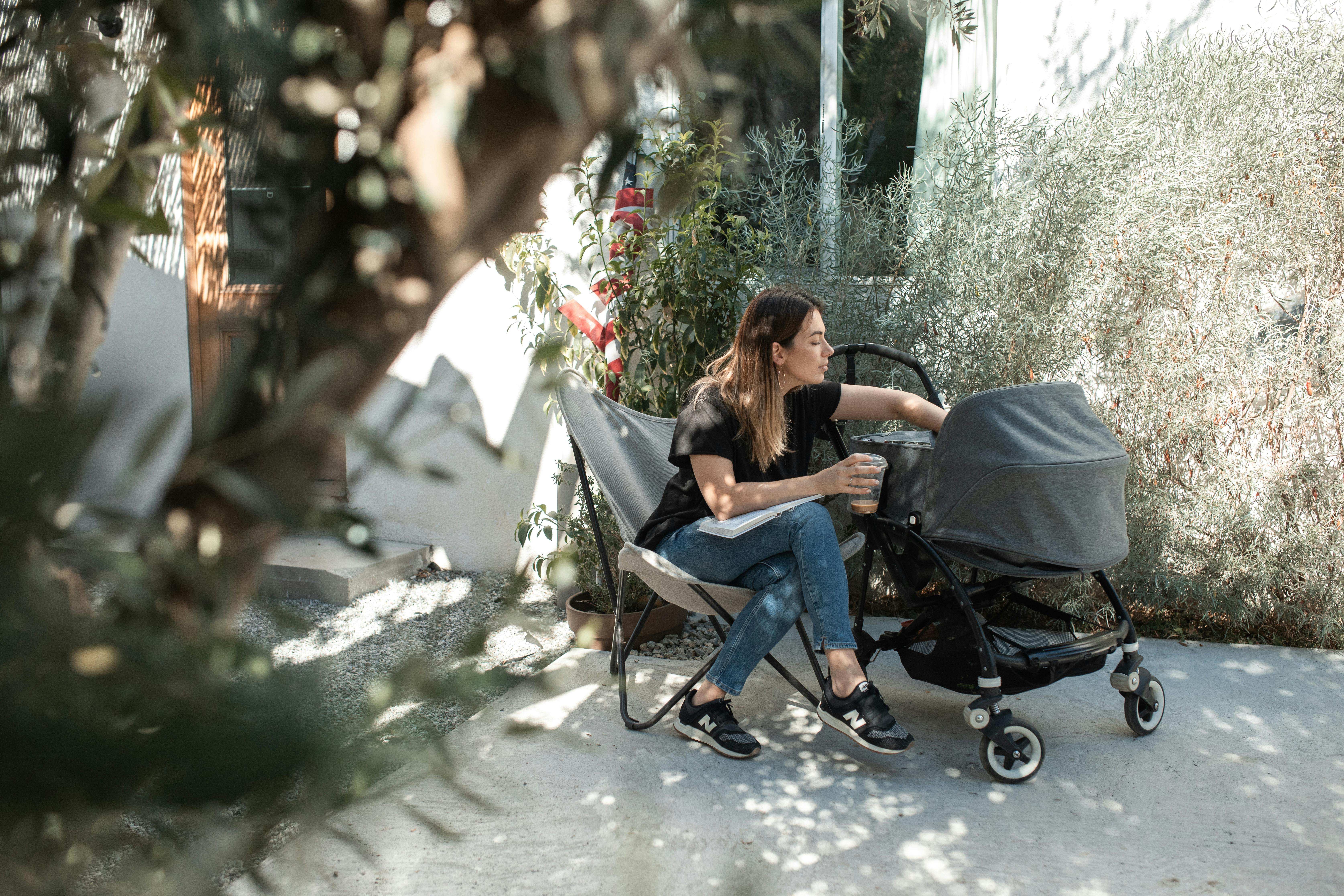 woman in black tank top and blue denim jeans sitting on black chair