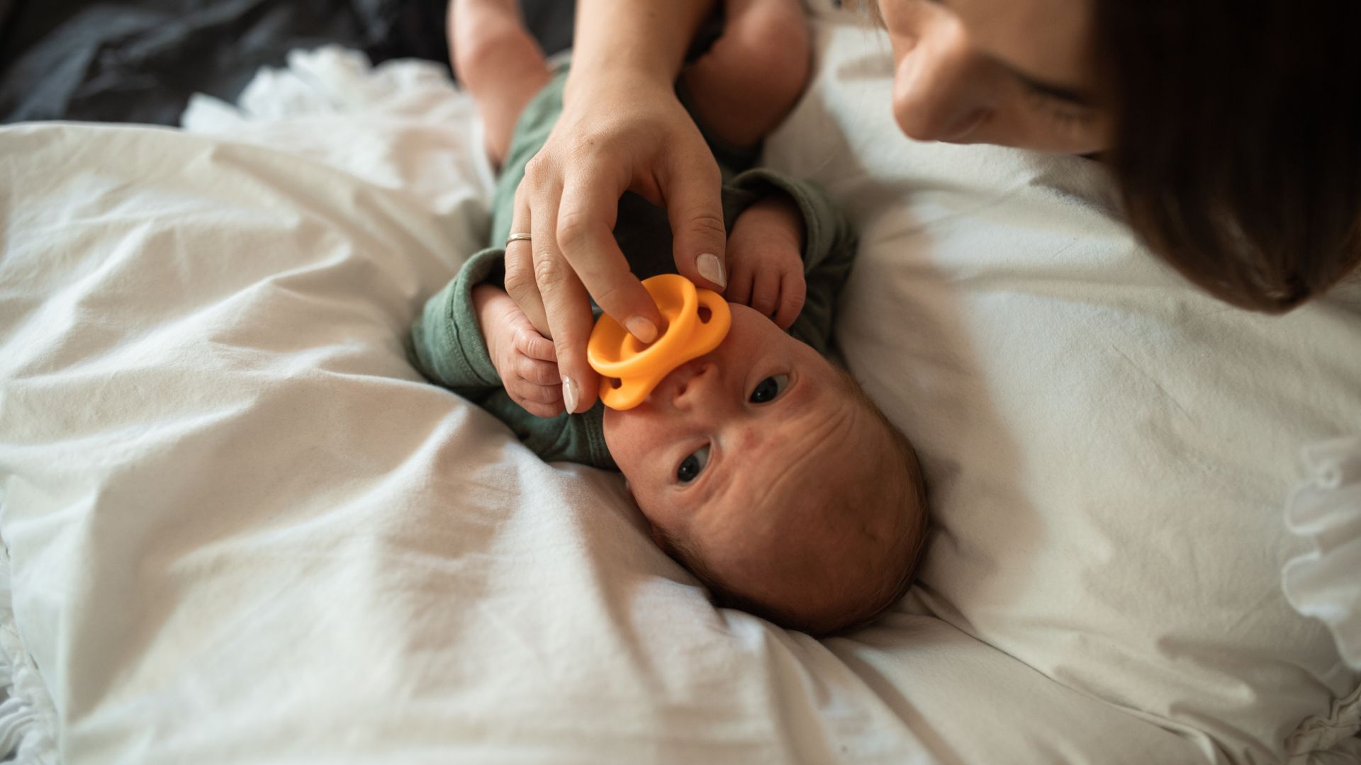 Modafinil for Postpartum Fatigue: An Effective Solution A tender moment of a mother with her newborn baby holding a pacifier indoors — modafinil for postpartum fatigue