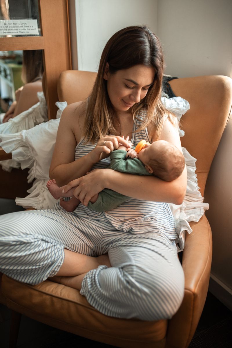 Parent holding baby near crib