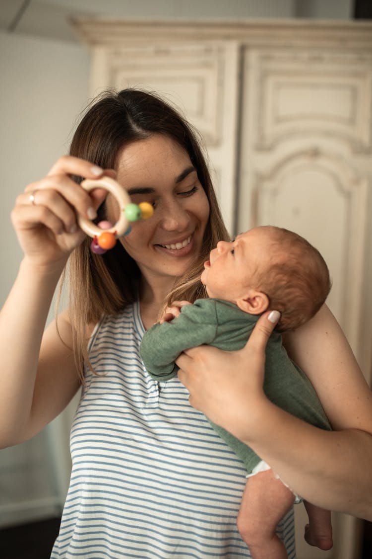 A Woman Playing With Her Newborn Baby