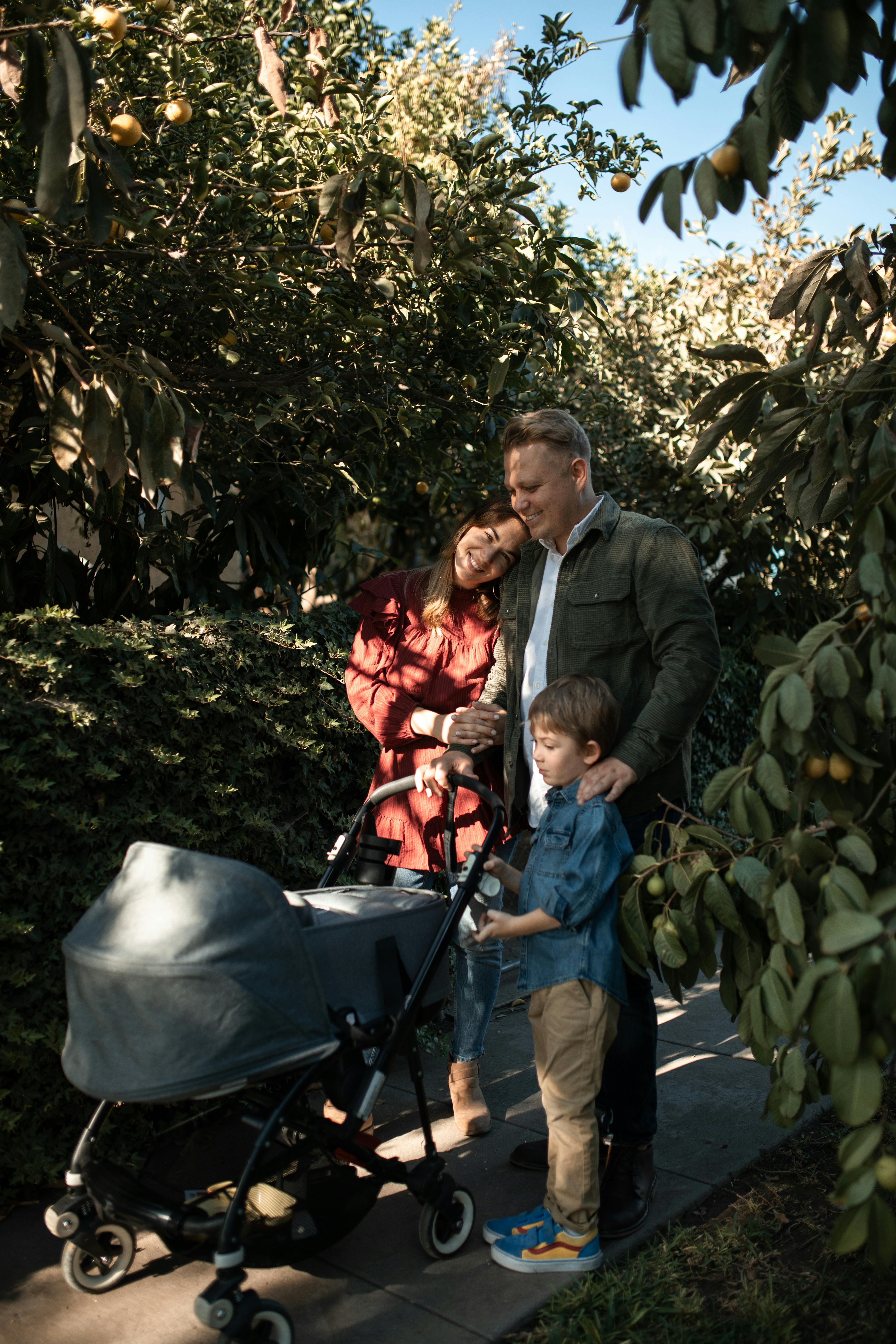 a happy family standing near the stroller