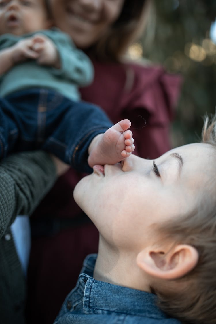 A Boy Kissing A Foot Of A Baby