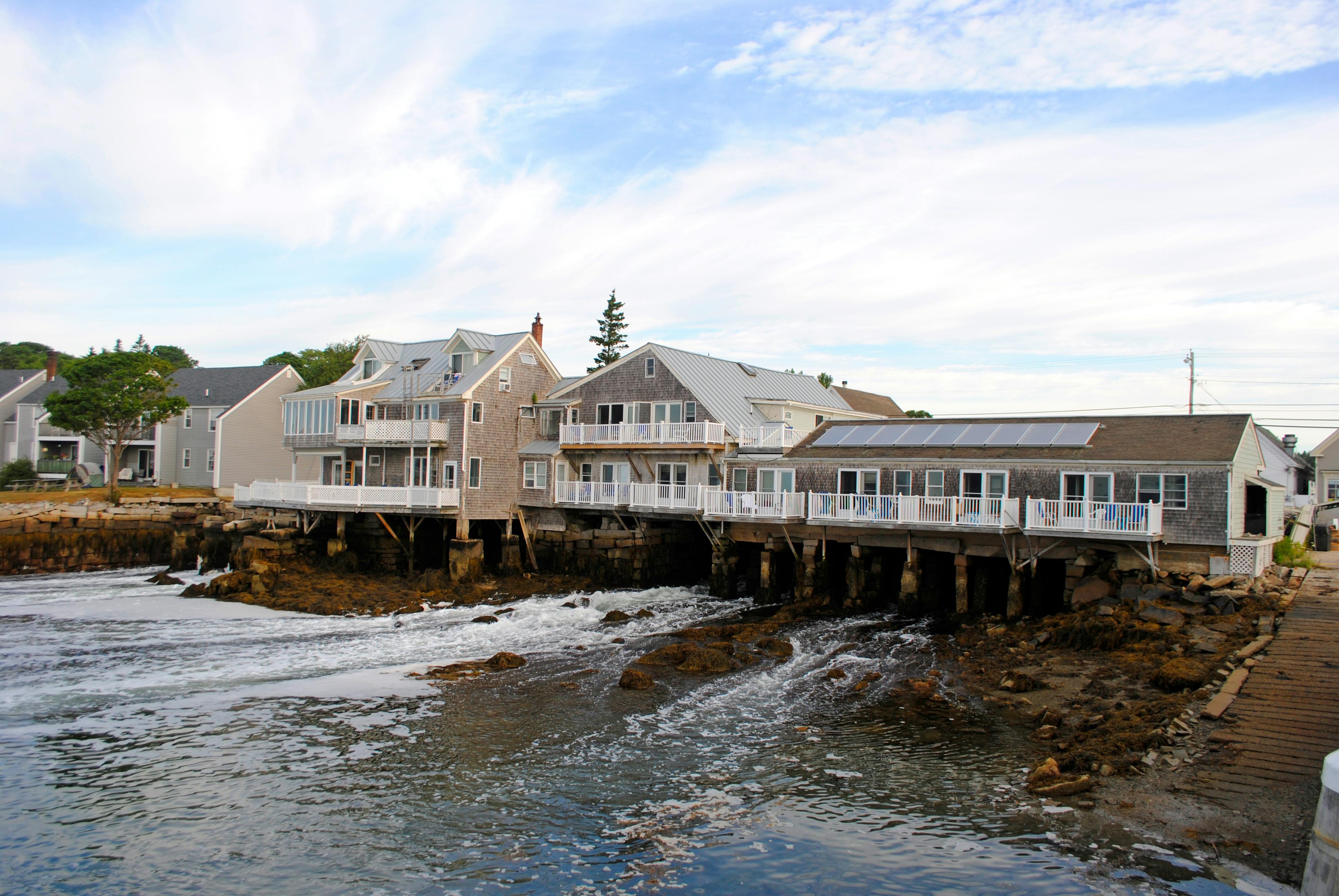 facades of houses near foamy sea in daylight