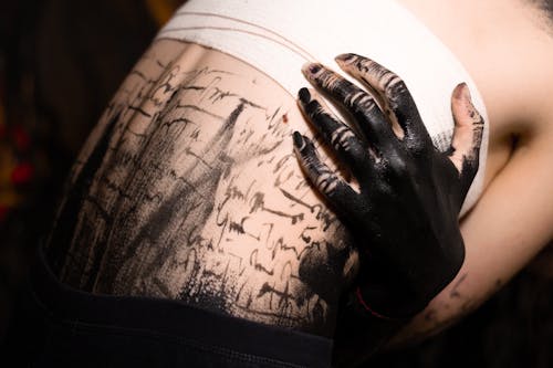 A Close-Up Shot of a Person Covered with Black Paint