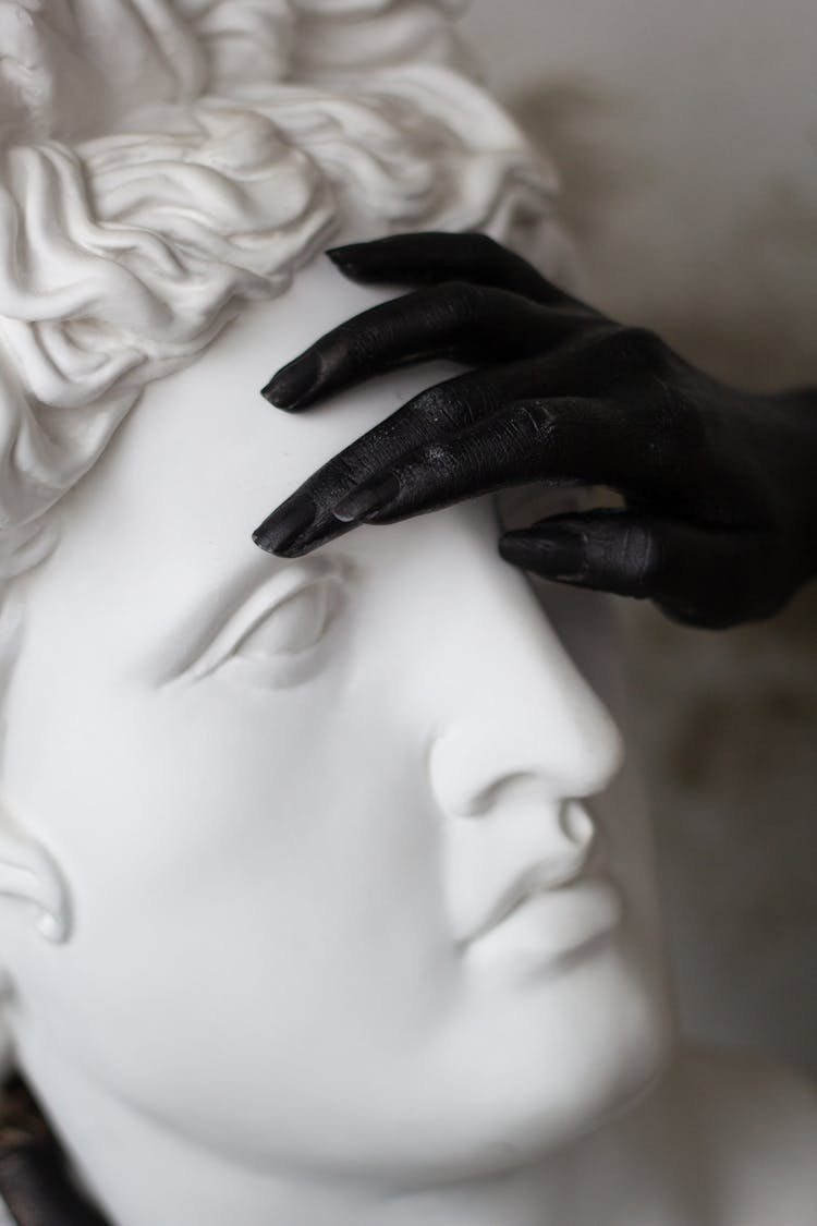 Painted Hand Touching A Statue