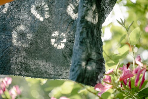 Wet painted cloth drying in garden with blooming flowers