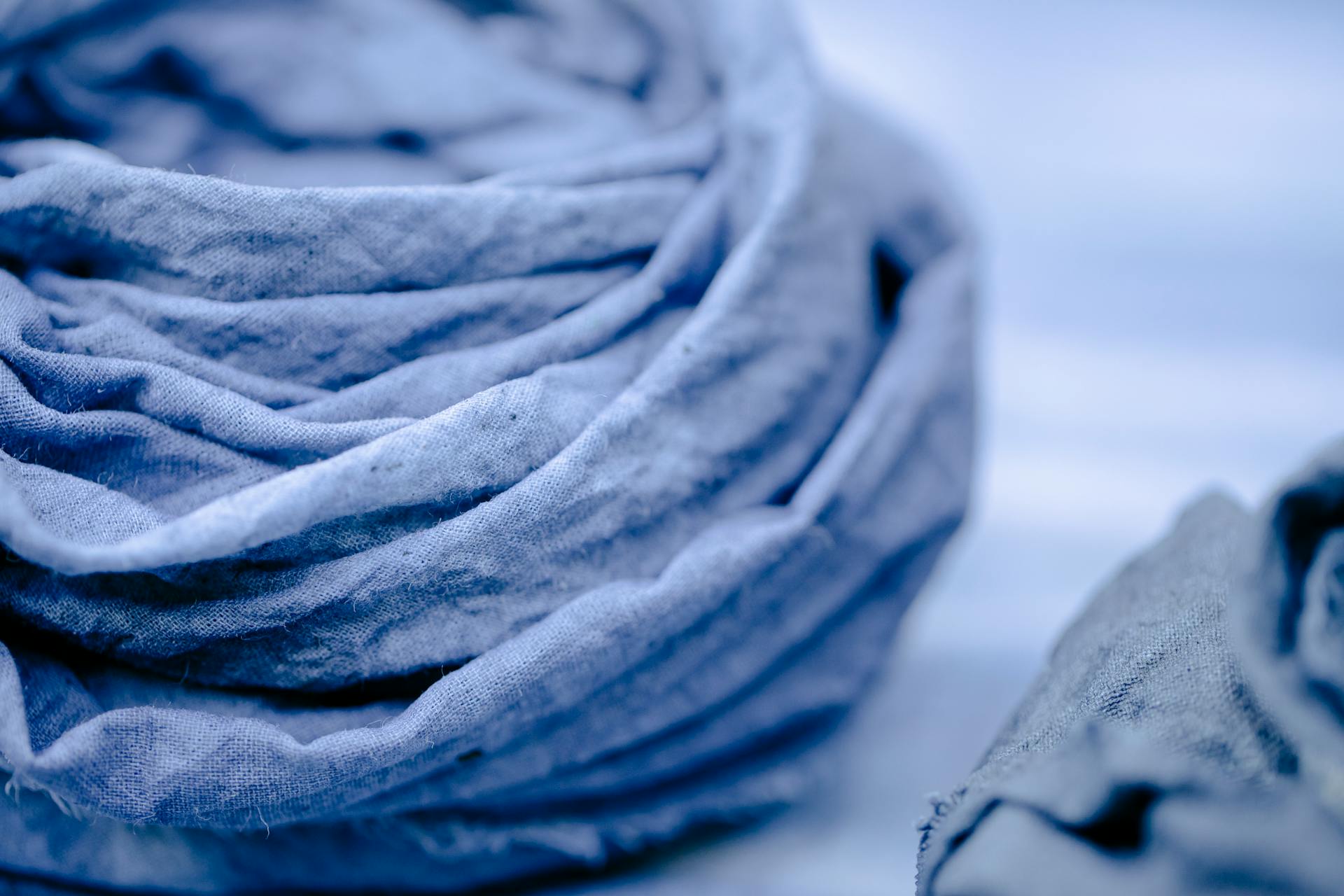 Detailed close-up of a blue textured fabric roll showcasing its creased and crumpled surface.