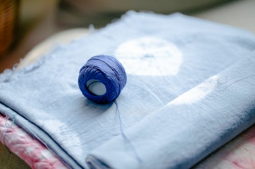 Blue yarn on heap of textile