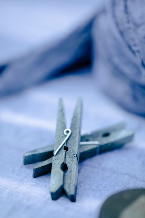 Free Wooden clothespins placed scattered on blue dyed fabric on table in modern light studio with professional supply on blurred background Stock Photo