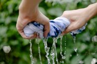 Crop person squeezing colorful textile