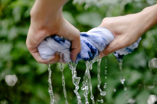 Crop person squeezing colorful textile