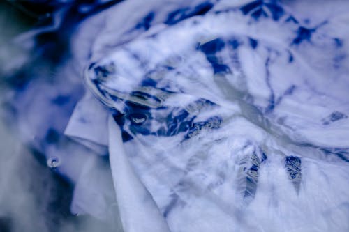From above of dyed cloth with abstract blue and white pattern in water