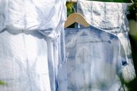 Collection of various washed clothes hanging on rope on fresh air on sunny day in summer