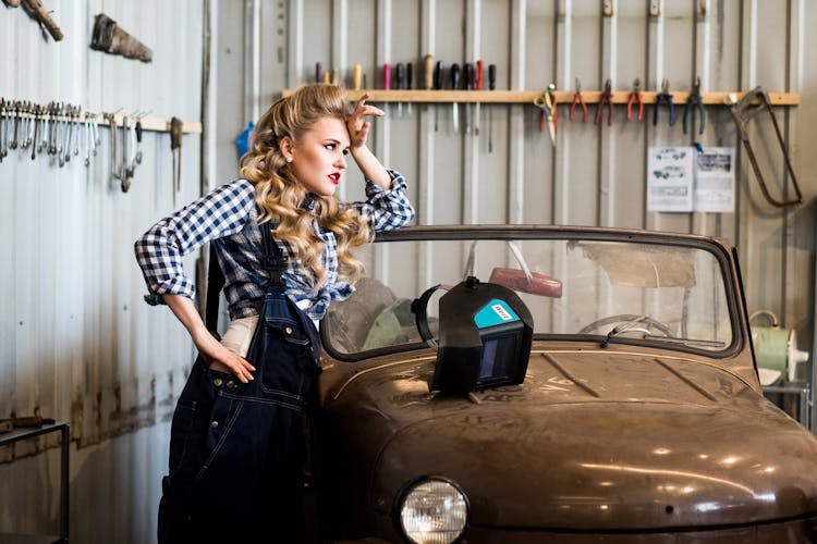 Woman In Overall Near Welding Helmet On Vintage Car