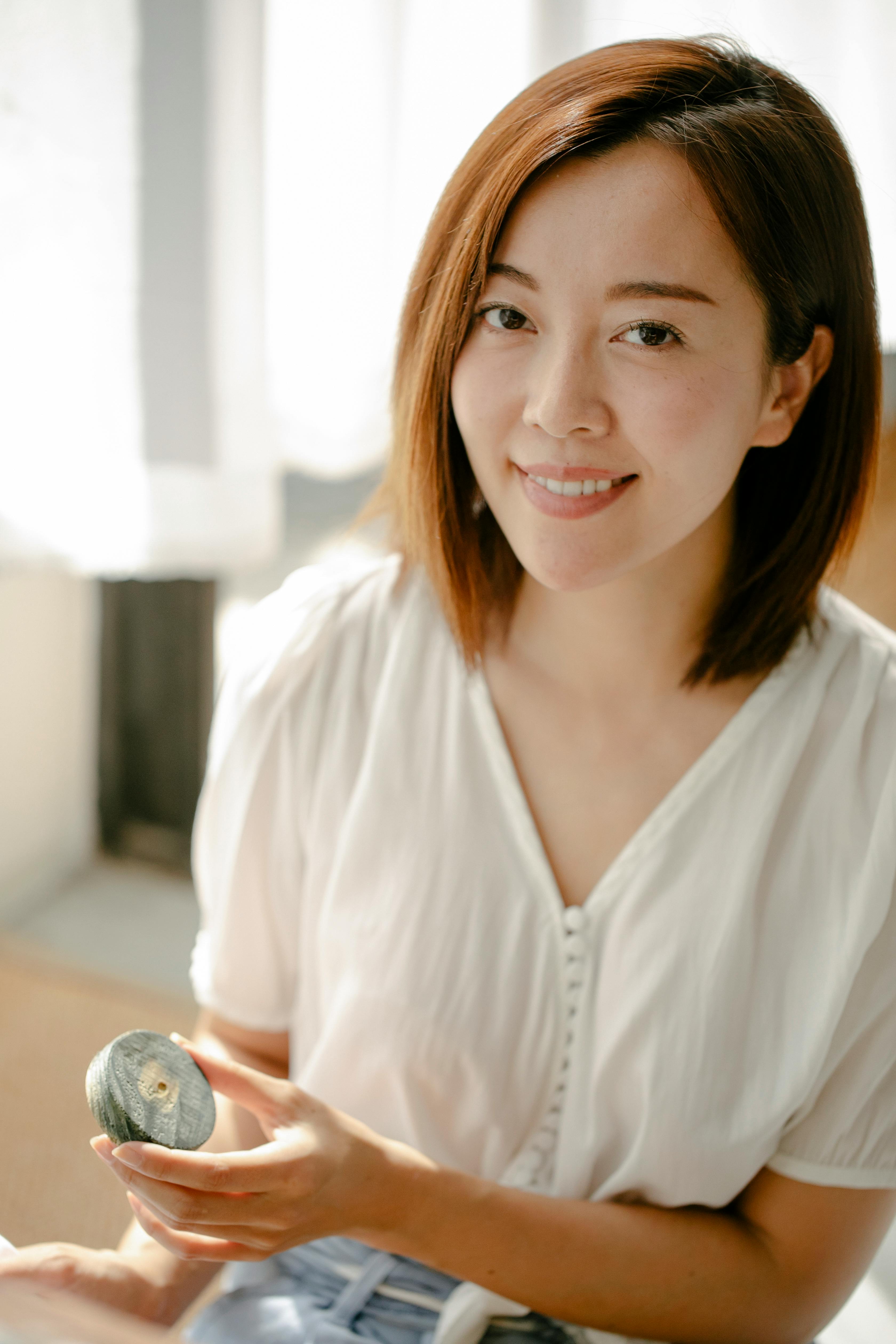 Smiling ethnic artisan with wooden block for shibori at home