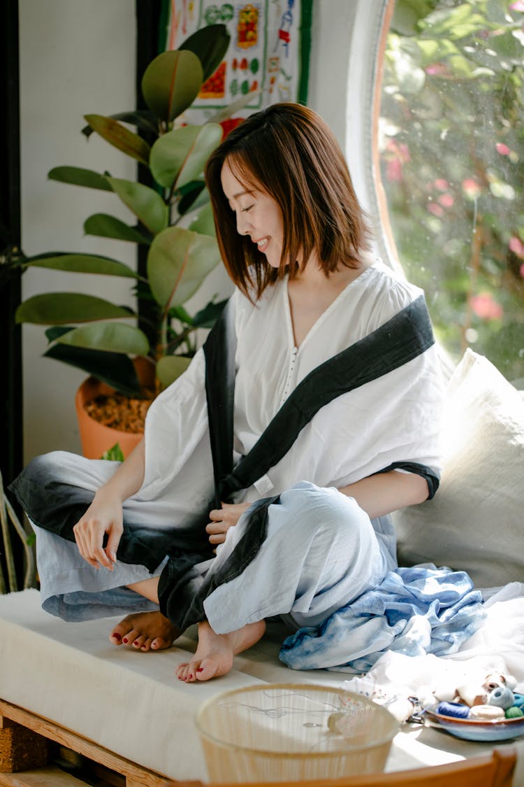 Cheerful Ethnic Artisan In Clothes With Shibori Ornament At Home