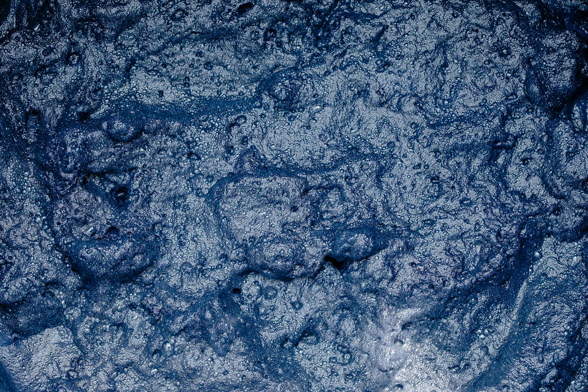 From above of surface of foamy indigo colored water during shibori tie dyeing process as abstract background