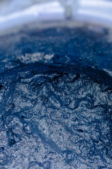 Closeup of vessel filled with blue water with drops and ripple on surface