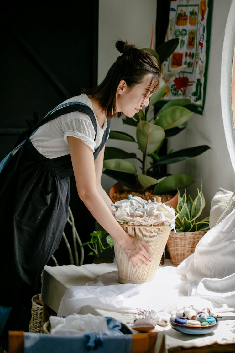 Young Asian Woman With Basket In Light Room