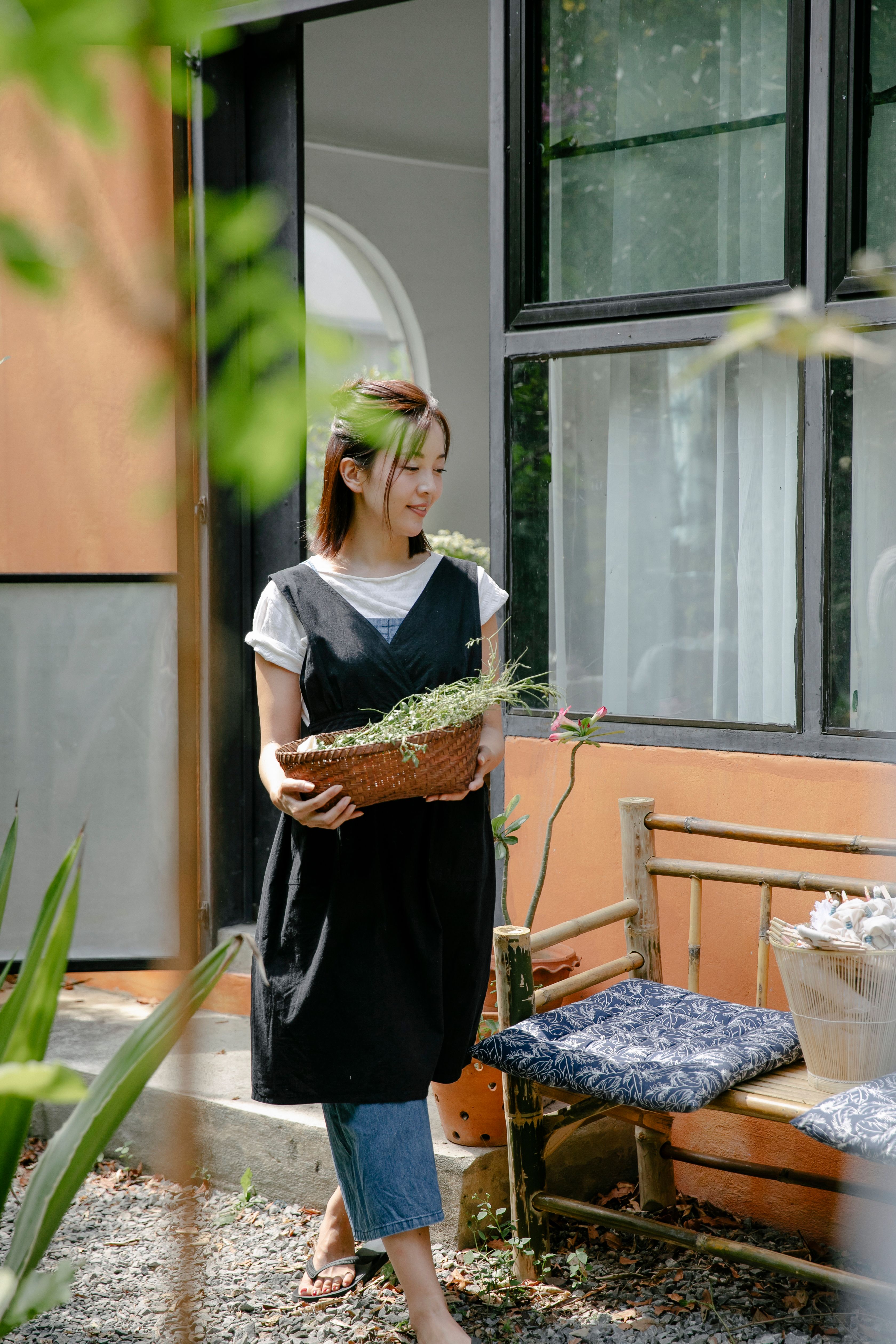 Young Asian woman with wicker basket in yard · Free Stock Photo