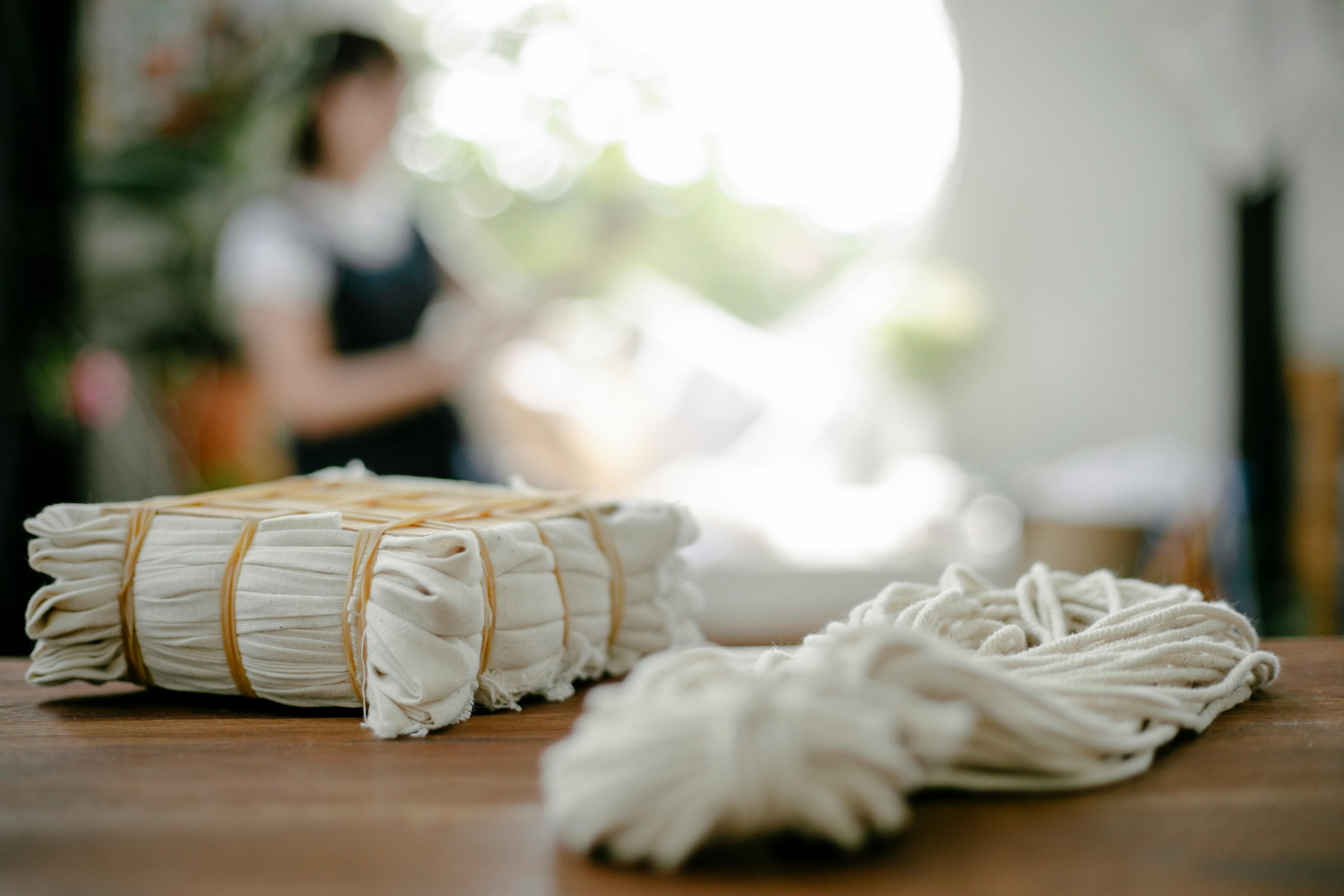 pile of tied natural fabric and white yarn on table