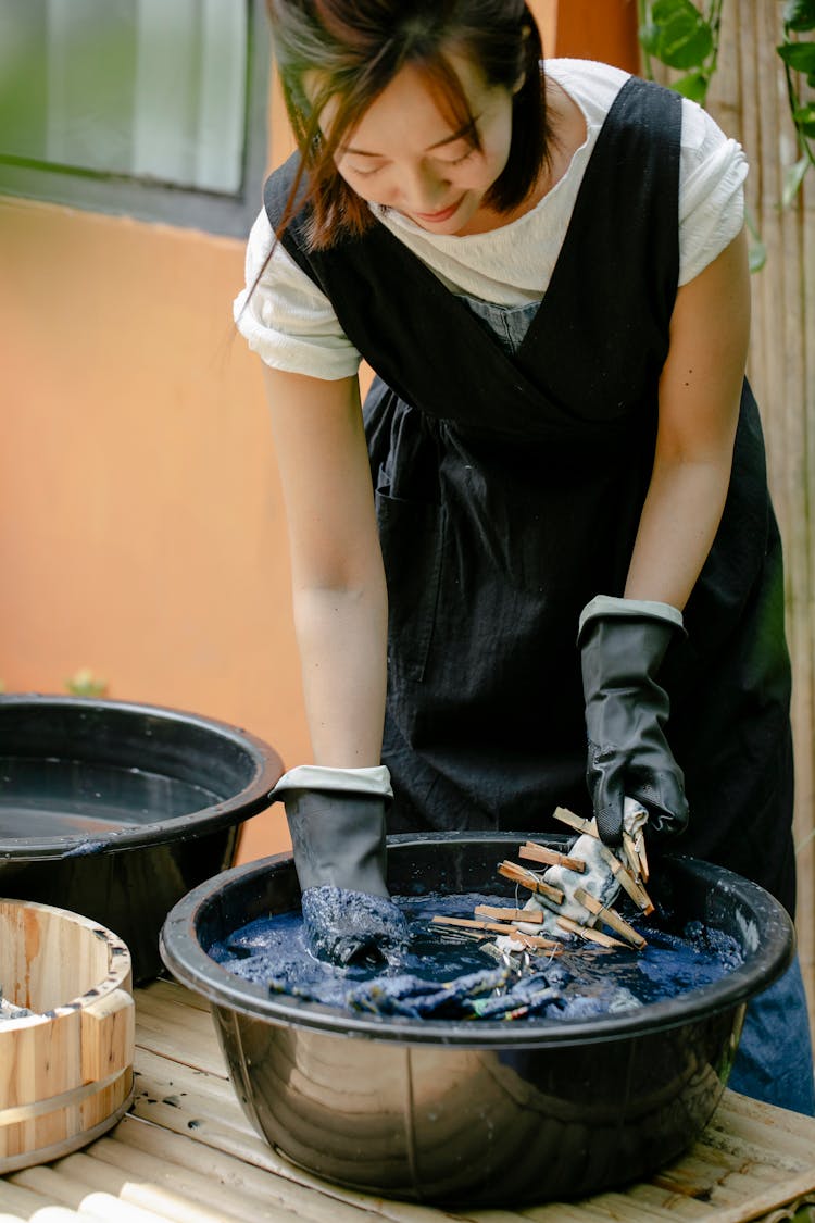 Crop Ethnic Artisan Painting Textile While Showing Shibori Technique