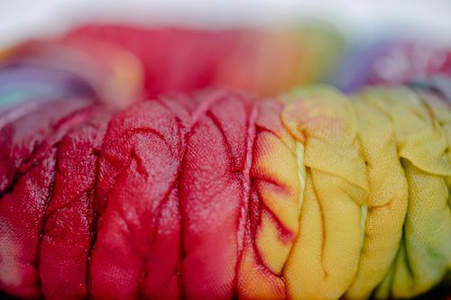 Free Closeup of pleated cloth with colorful paints and threads representing Japanese tie dye technique on blurred background Stock Photo