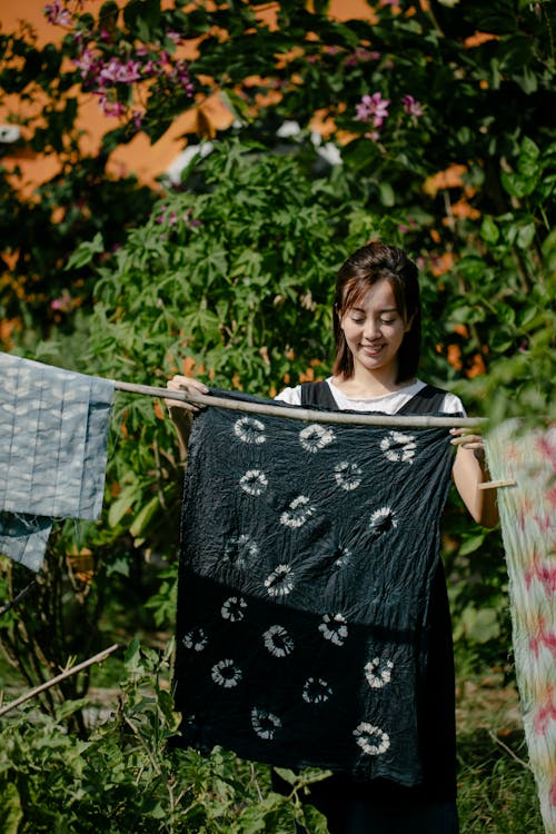 Woman Hanging Sheets Outside to Dry