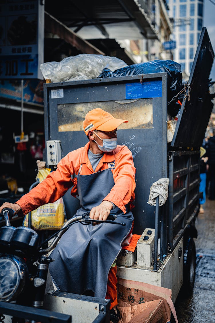 Worker Driving Vehicle With Garbage